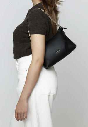 Black leather bag with a textured finish, triangular shape, and silver chain strap. Small branding detail on the front.