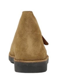 Bottine en cuir suédé marron avec un talon rond, une finition texturée et une semelle en caoutchouc noire contrastante. Design simple avec des accents minimaux.