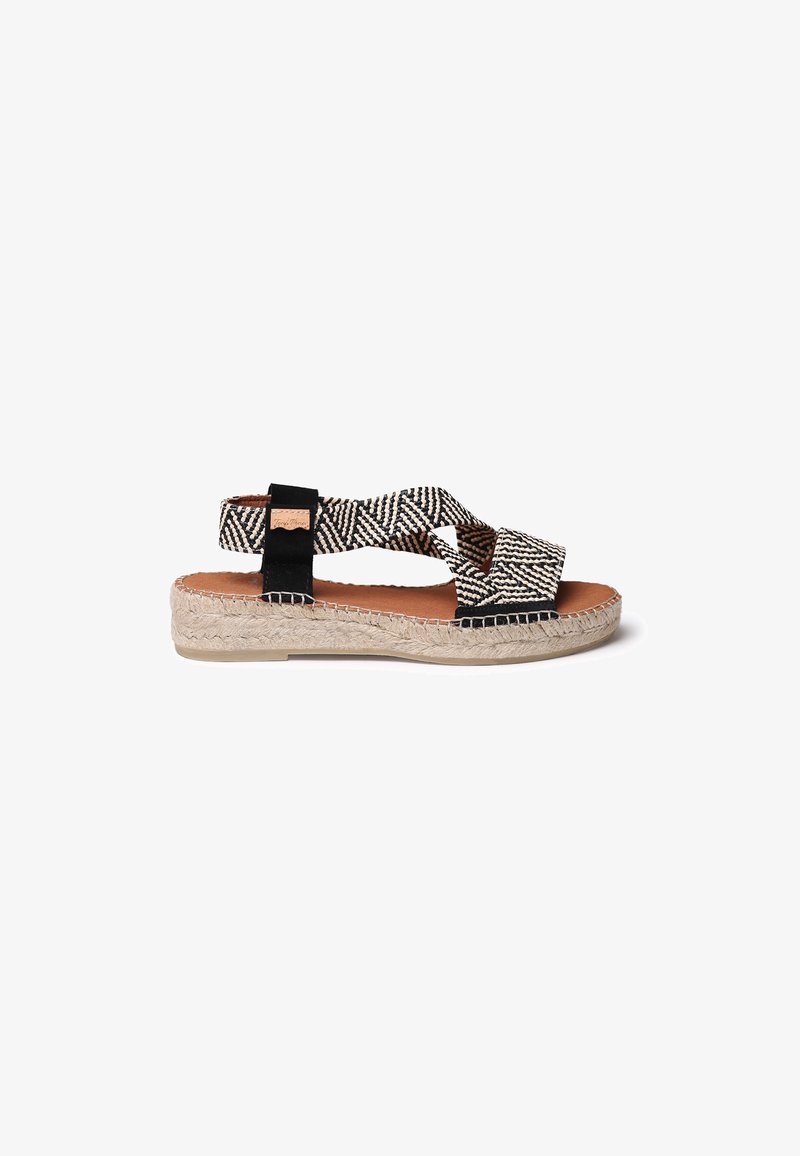 Espadrilu sandāles ar krustveida melnbaltajiem rakstiem, austs jūtu zole, ar gludu brūnu kāju daļu un melniem akcentiem.