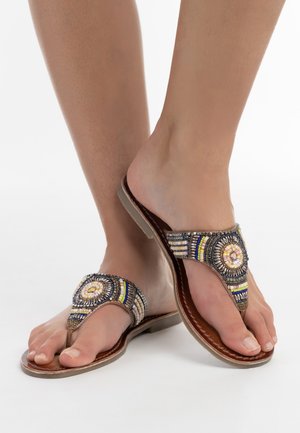 Perlenbesetzte Zehensandalen mit einem runden dekorativen Element und mehreren bunten Perlen auf einer braunen Lederbasis; flache Sohle, offene Zehenkonstruktion.