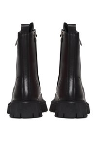 Zwarte leren enkelboots met een textuurafwerking, zijritsen en robuuste, geribbelde rubberen zolen. Standaard ontwerp met minimale details.
