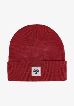 Red knit beanie with a folded cuff, featuring a square patch with a black logo. The texture is ribbed, made from a soft fabric.