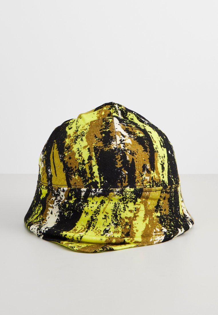 Kapelusz typu bucket z abstrakcyjnym wzorem w odcieniach żółtego, brązowego, czarnego i białego, wyświetlany na jednolitym jasnoszarym tle.