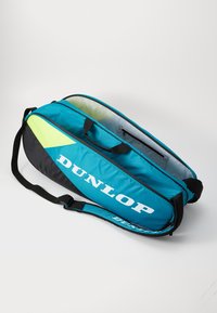 Tennis Tasche in Türkis und Schwarz mit weißem "DUNLOP" Branding. Verfügt über einen Tragegriff, einen verstellbaren Schultergurt und ein Reißverschlussfach.