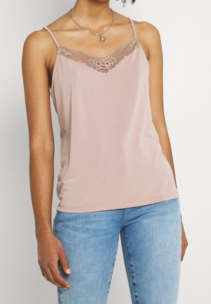 Vaaleanpunainen hihaton toppi, jossa pitsireunus pääntiessä, ohuet säädettävät hihnat ja pehmeä, sileä materiaali. Yhdistetty sinisiin farkkuihin.