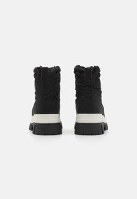 Sorte høye sneakers med polstret skaft, teksturert stoff og hvit mellomsåle. Kraftig gummisåle med spor for grep.