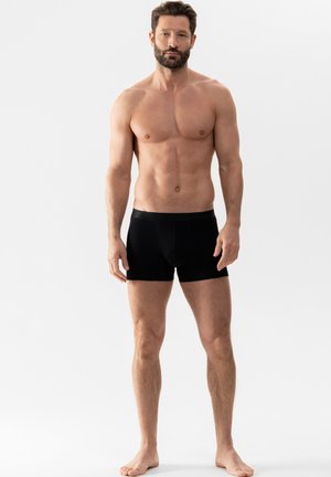 Zwarte boxershorts van gladde stof, met een strakke pasvorm en een subtiele tailleband. Het ontwerp is eenvoudig zonder zichtbare patronen.
