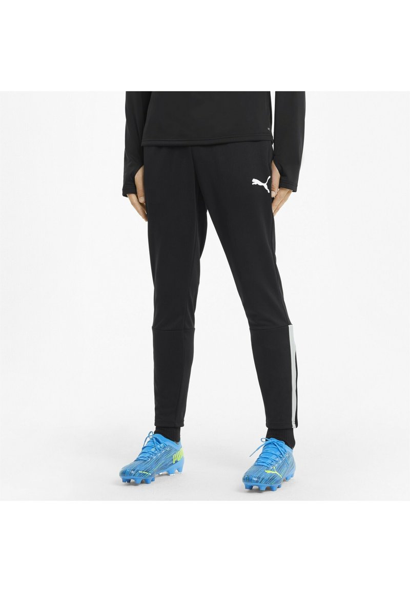 Sorte atletiske bukser med en tætsiddende pasform, udstyret med et hvidt Puma-logo og grå accentstriber langs siderne. Glat, strækbart stof.