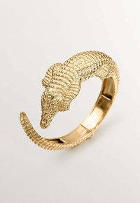 Pulsera de oro en forma de cocodrilo con escamas texturizadas y un acabado pulido y elegante. Diseño curvado con extremo abierto para un fácil uso.