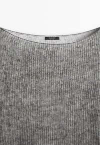 Pull gris en maille avec de fines côtes verticales et une étiquette Massimo Dutti cousue à l'intérieur de l'encolure, fabriqué en Chine.