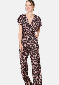 Luipaardprint jumpsuit in roze en zwart, met korte mouwen, een gewikkelde voorkant en een gestrikte taille; soepel materiaal en wijde pijpen.