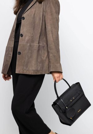 Schwarze Handtasche mit strukturiertem Fischgrätenmuster, goldfarbenen Hardware-Akzenten, runder Reißverschlusslasche und oberen Griffen, kombiniert mit einem braunen Wildleder-Blazer.