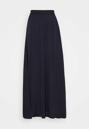 Jupe longue noire plissée avec une ceinture ajustée et un tissu fluide qui descend jusqu'au sol.