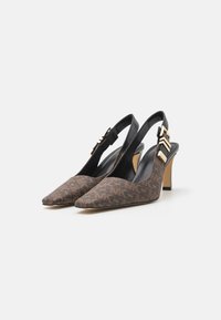Zapatillas de tacón con diseño marrón y tiras traseras, con punteras afiladas, detalles en cuero negro y un detalle de hardware en tono dorado en la correa.