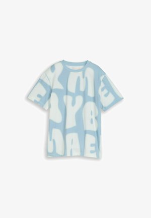 Camiseta de manga corta de color azul claro con patrones abstractos de letras blancas de gran tamaño dispersos por toda la tela.