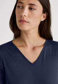 Marineblauwe V-hals t-shirt gemaakt van zachte stof, met een gladde textuur en korte mouwen, met een schone, eenvoudige uitstraling.