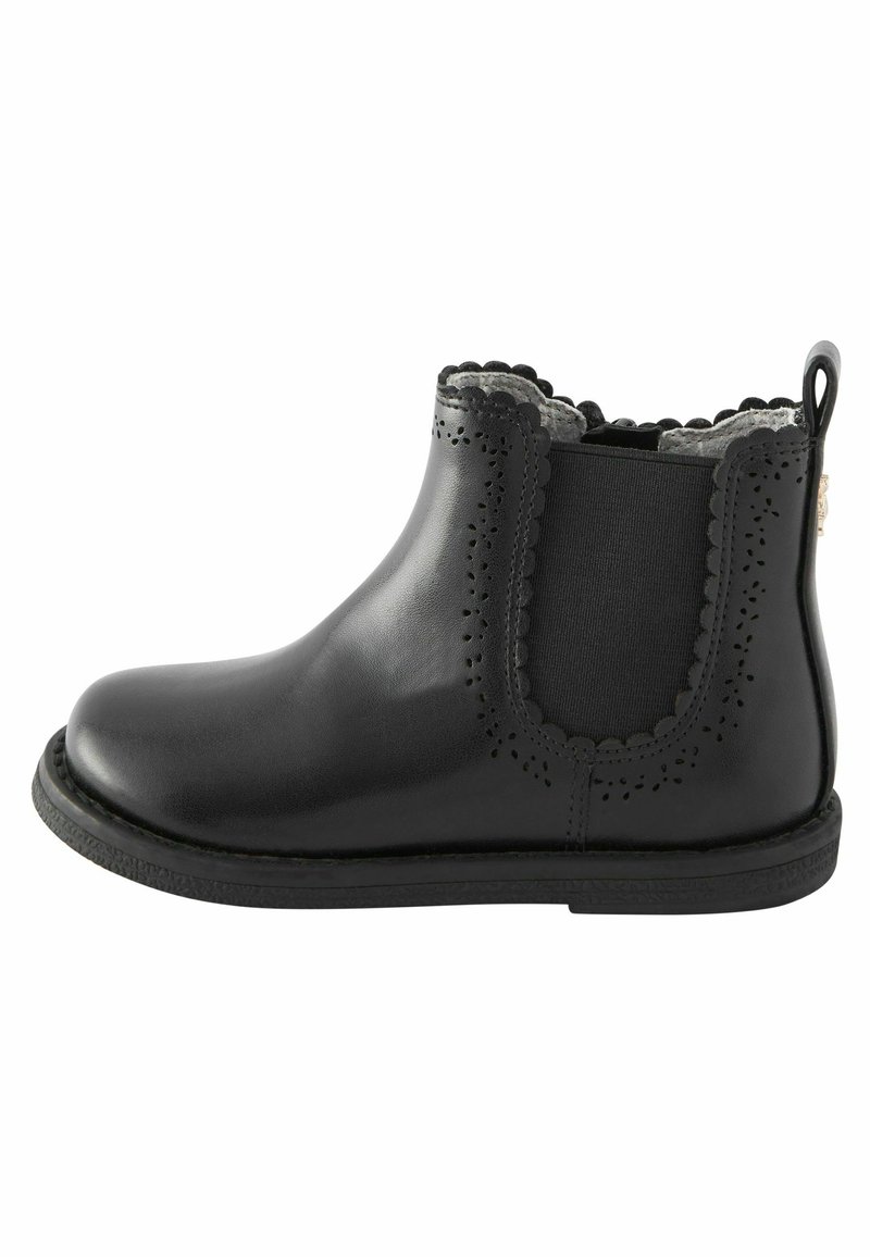 Bottine en cuir noir avec bords festonnés, détails perforés, panneau latéral élastique et languette au talon.