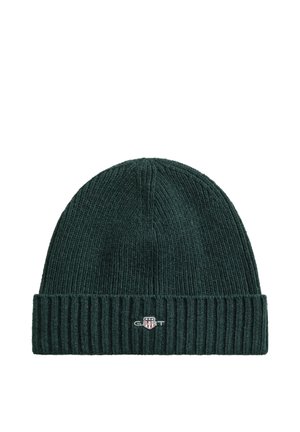Dunkelgrüne, gerippte Strickmütze mit umgeschlagenem Bündchen und kleinem GANT-Logo-Patch vorne in der Mitte.