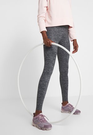 Legging gris chiné, sweatshirt court rose clair et baskets violettes ; le modèle tient un cerceau hula hoop blanc.