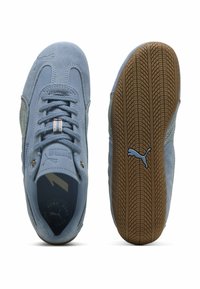 Jasnoniebieskie zamszowe trampki Puma z sznurowadłami, jedna pokazana od góry, druga — podeszwa gumowa z logo Puma.