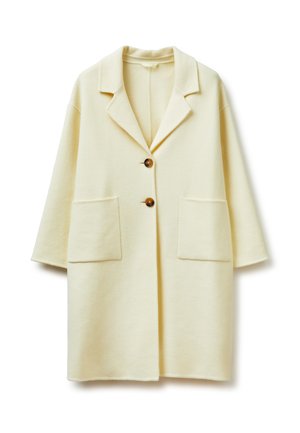 Abrigo largo color crema con cuello con muesca, dos botones marrones, dos grandes bolsillos frontales y mangas de tres cuartos.