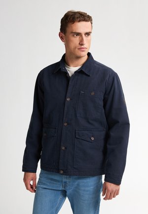 Navyblauwe werkjas van katoen met een puntige kraag, knoopsluiting, borstzak en twee voorste klepzakken.