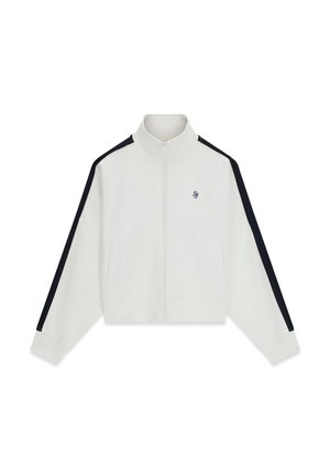 Veste blanche zippée avec des rayures noires sur les manches et un petit logo brodé sur le côté gauche de la poitrine, équipée de poches avant et d'un col haut.