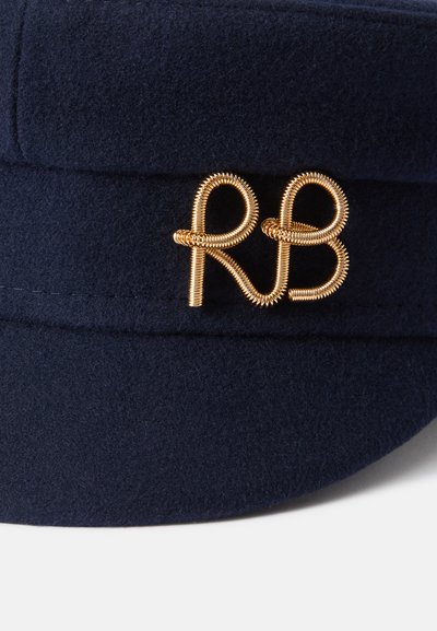 Jūras zila vilnas cepure ar zelta vītnes "RB" logotipu. Cepure ir strukturēta formā ar gludu tekstūru.