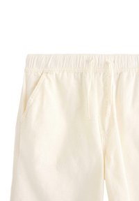 Ljust krämfärgade sweatpants med elastisk midja och dragsko. Har sidofickor och mjukt, texturerat tyg.