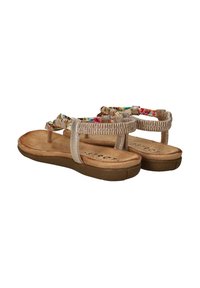 Sandales beiges avec des brides à motif floral, semelle douce et semelle texturée. Présente des accents métalliques sur les brides.