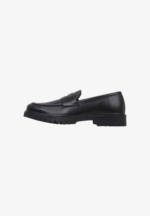 Mocasines de cuero negro con un acabado suave, puntera redondeada y un sutil diseño grabado. La suela exterior es gruesa y texturizada para mayor agarre.