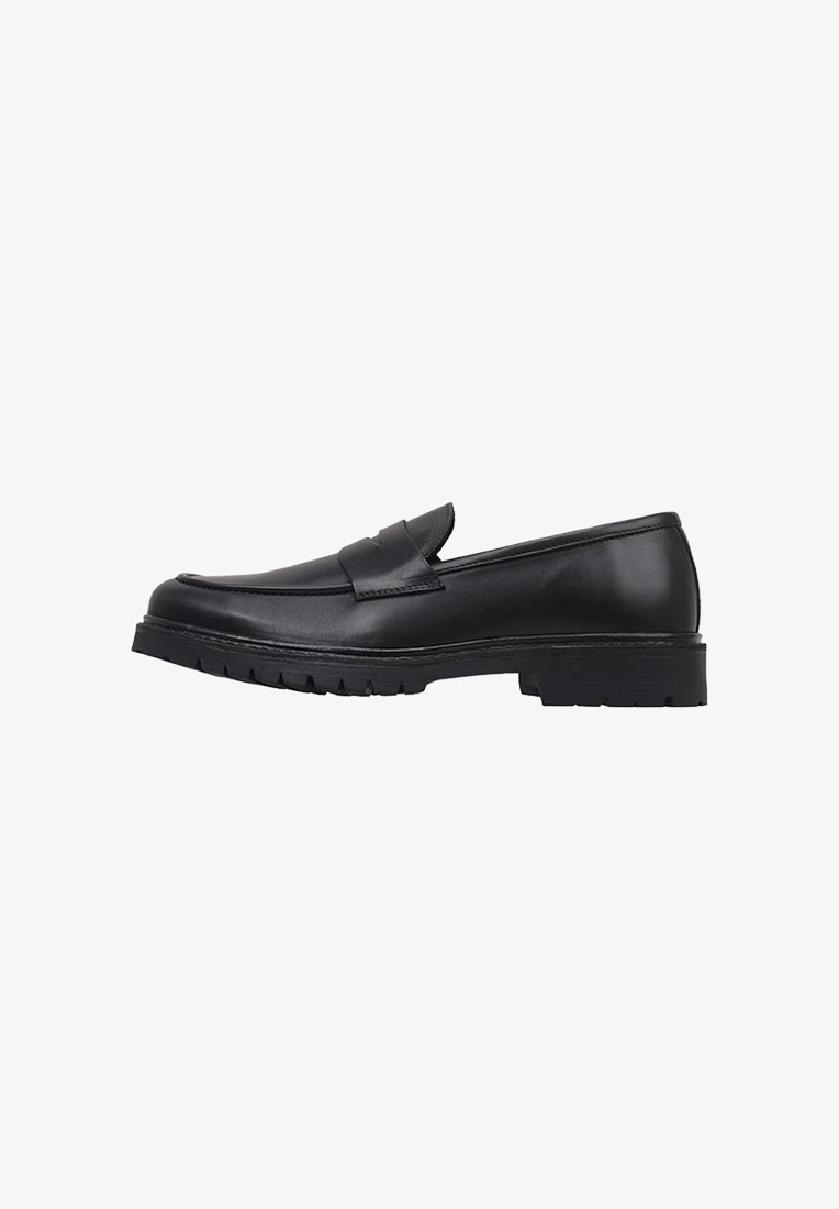 Mocasines de cuero negro con un acabado suave, puntera redondeada y un sutil diseño grabado. La suela exterior es gruesa y texturizada para mayor agarre.