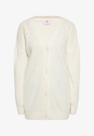 Biały robiony na drutach kardigan z dekoltem w serek, z zapięciem na guziki i luźnymi rękawami. Posiada teksturowe wzory i małe detale w postaci oczek na ramionach.