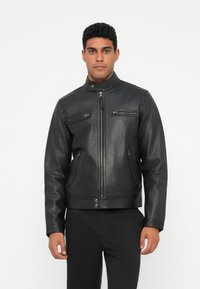 Juodas odinis švarkas su stovinčiu apykakl�ės kraštu, priekyje užtrauktuku, ir keturiais užtrauktukais uždaromais kišeniais; lygus paviršius ir prigludusi forma.