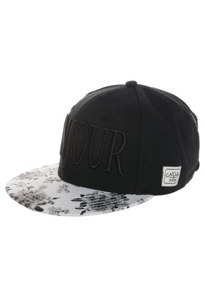 Schwarze Snapback-Kappe mit großem, gesticktem "TOUR"-Schriftzug und einem weißen, floral gemusterten flachen Schirm, mit einem kleinen "CAYLER & SONS"-Etikett.