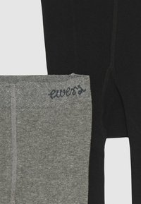 To sæt leggings vist: et par i sort og et par i grå. Det grå par har en tekstureret talje med "ewers" logo, begge har en glat overflade.