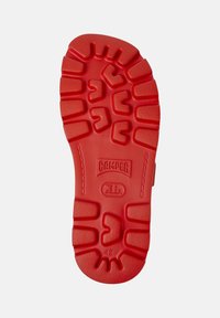 Red rubber shoe sole with textured grip patterns and prominent "Camper" logo. Features a circular design and marked size "42."