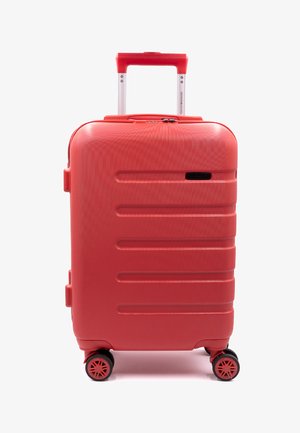 Valigia rigida rossa con superficie texturizzata, caratterizzata da scanalature orizzontali, manico telescopico, quattro ruote girevoli e un lucchetto.