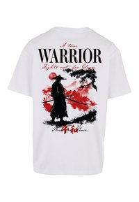 T-shirt bianco in cotone con una stampa grafica di una silhouette di guerriero in nero circondata da accenti rossi e testo di ispirazione asiatica.