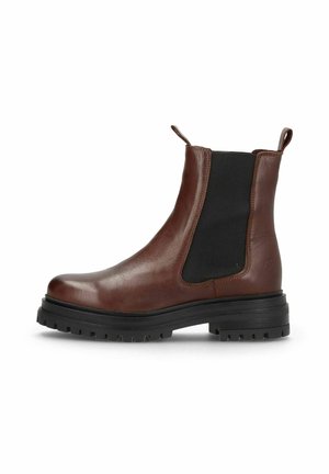 Bottine Chelsea en cuir marron avec des panneaux latéraux élastiques noirs et une semelle épaisse noire à crampons, vue de côté extérieur sur fond blanc.