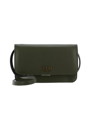 Sac bandoulière vert en similicuir avec une fermeture à rabat. Présente un logo "GUESS EST 1981" en or bien visible, avec une bandoulière amovible.