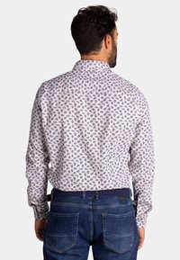 Langarm overhemd met witte stof en kleine blauwe bladerenpatronen, en een klassieke kraag. De achterkant toont een casual pasvorm en stikseldetails.