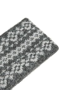 Šedá a biela textília s vzorom, ktorá sa vyznačuje jemnou, chlpatou textúrou s geometrickým dizajnom. Obdĺžnikový tvar s strapatými okrajmi.