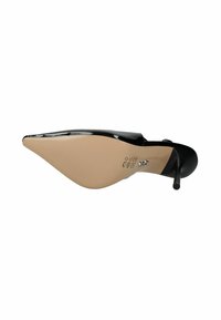 Zapato de tacón alto de charol negro con punta afilada, tacón fino tipo stiletto y suela lisa de color beige con detalles texturizados.