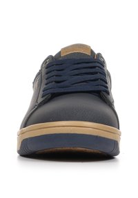 Sneaker navy con tomaia in sintetico liscia, lacci tono su tono, una etichetta in pelle marrone sulla linguetta e una suola in gomma naturale leggera.