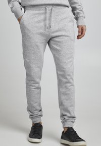 Grijze sweatpants van zachte, gestructureerde stof. Voorzien van een elastische tailleband met verstelbare trekkoorden en zijzakken. Slim fit ontwerp.
