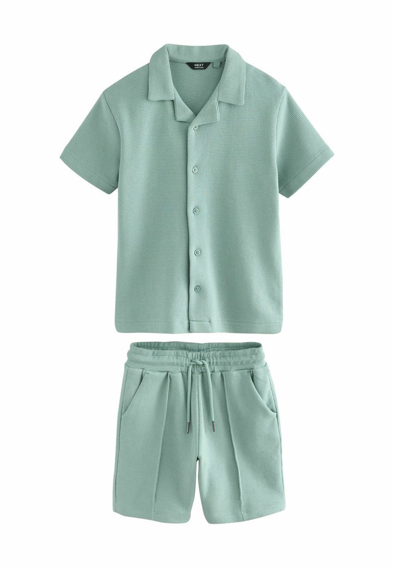 Short-sleeve button-up shirt and drawstring shorts set in textured light green fabric, designed for casual wear.