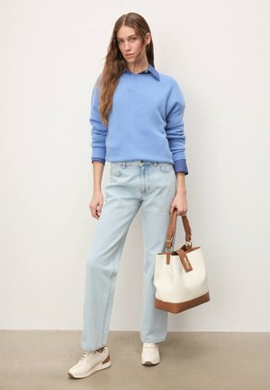 Hele sinine kampsun soonikuga varrukate otstes, heledad teksad, valge ja helepruun ämbrikott ning valged tossud helepruuni detailidega. Siledad tekstuurid.