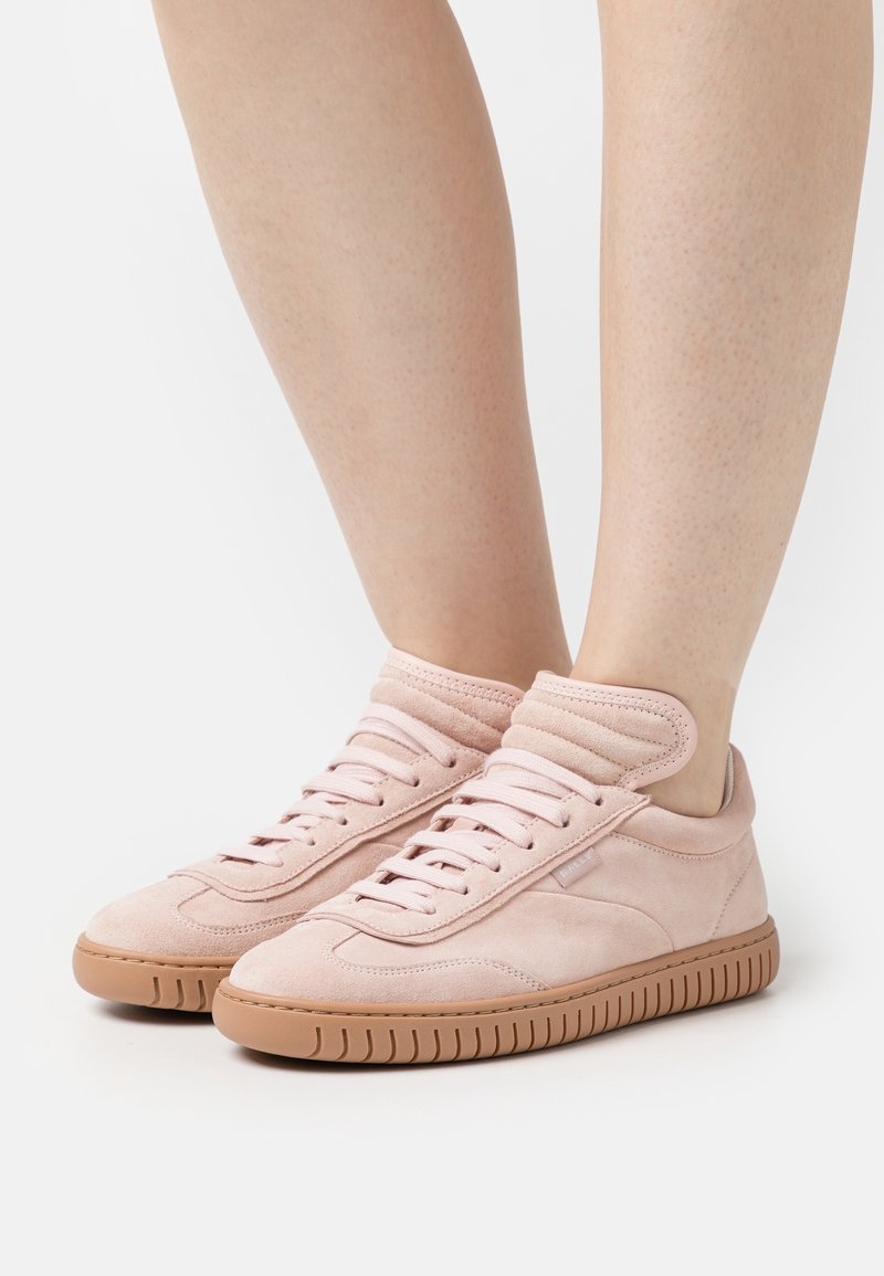 Sneakers in suede rosa chiaro con design a caviglia alta, dotate di lacci piatti, colletto testurizzato e suola in gomma con scanalature verticali.