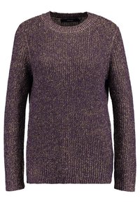 Neulepusero tumman violetissa, jossa on kultaisia sävyjä. Varustettu pyöreällä kaula-aukolla ja pitkillä hihoilla. Kankaan pinta on teksturoitu, ja helmassa sekä hihoissa on joustinneule.